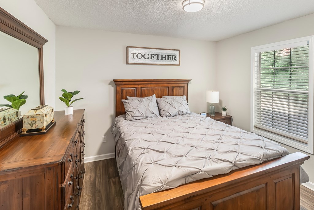 a bedroom with a bed and a dresser and a window