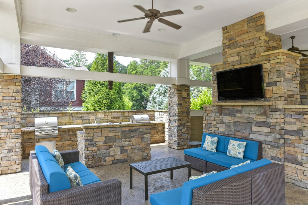 a covered patio with a fireplace and a tv