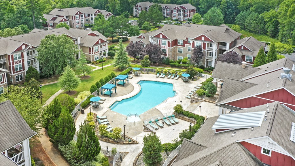 an aerial view of a swimming pool in a community with houses