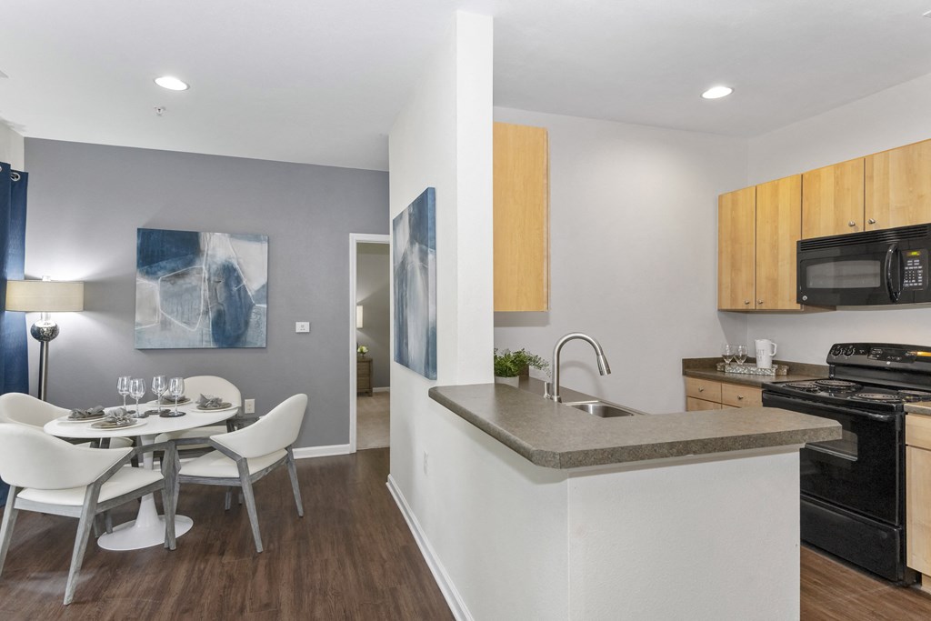 a kitchen and dining area with a table and chairs and a black stove