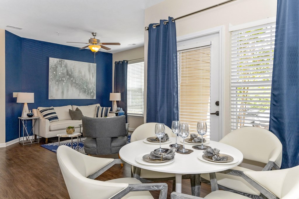 a living room with blue walls and a white table and chairs