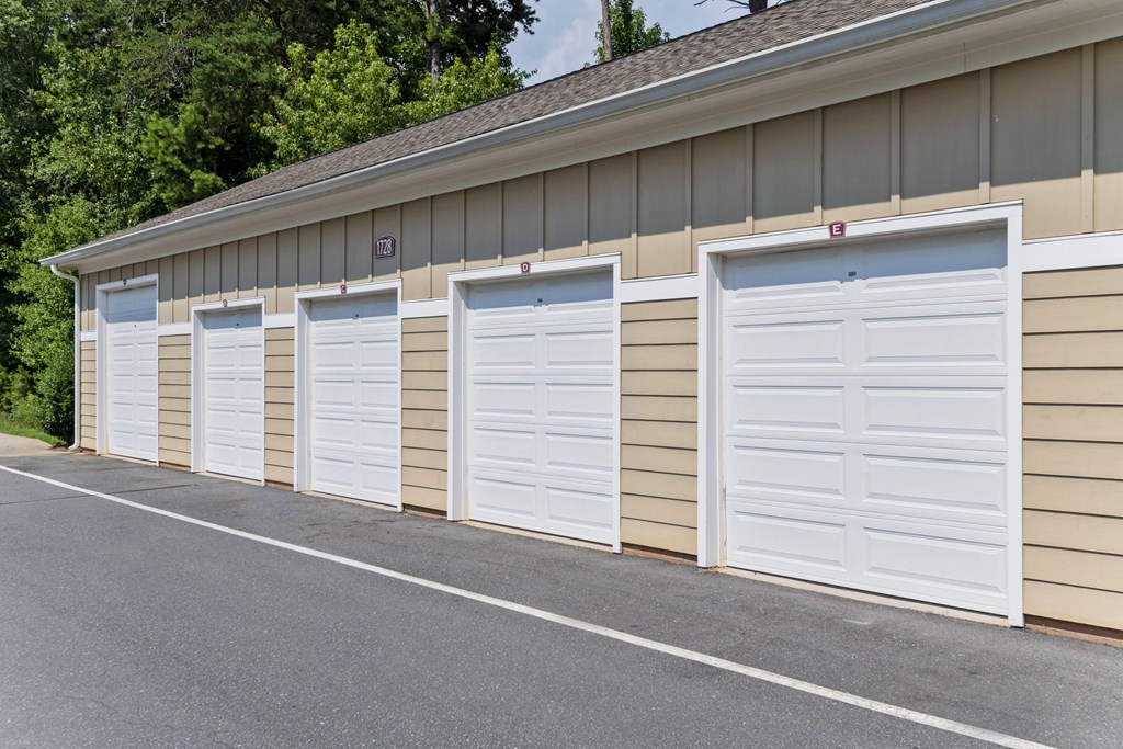 a row of white garage doors on the side of a building