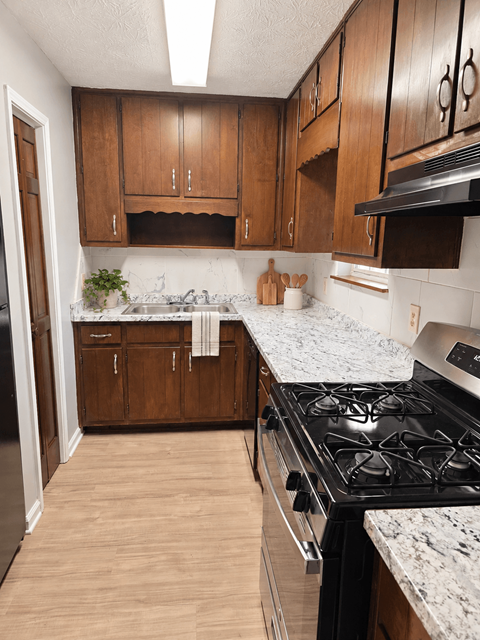 A kitchen with wooden cabinets and a black stove top.
