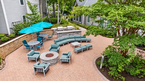 A patio with a table and chairs and a blue umbrella.