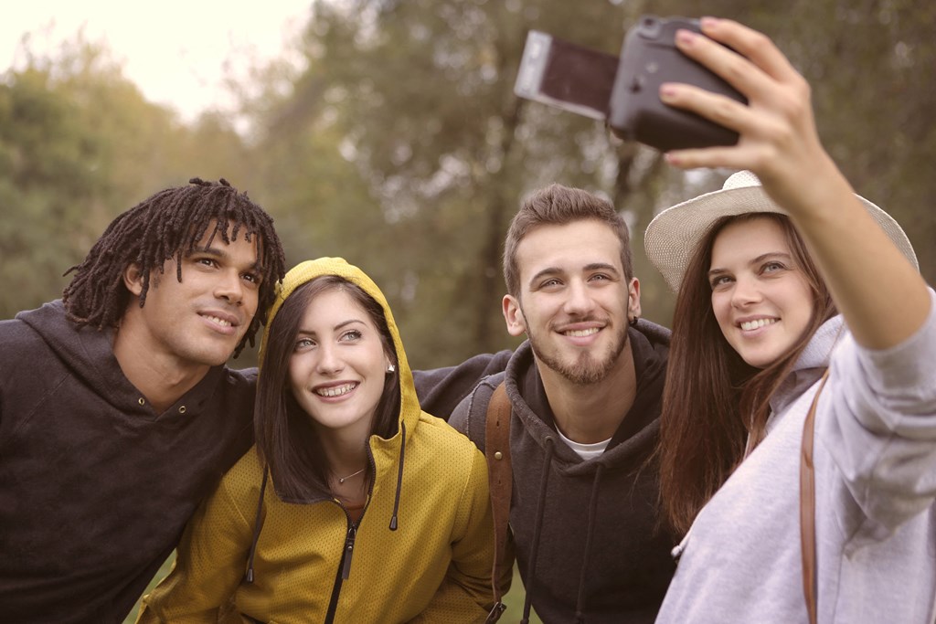 a group of friends taking a picture with a cell phone