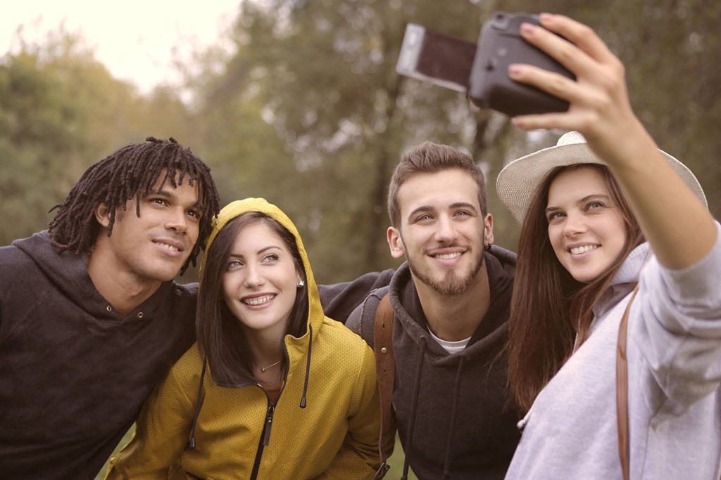 a group of friends taking a picture with a cell phone