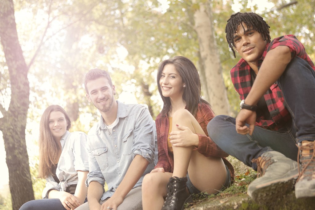 a group of young people sitting in the woods