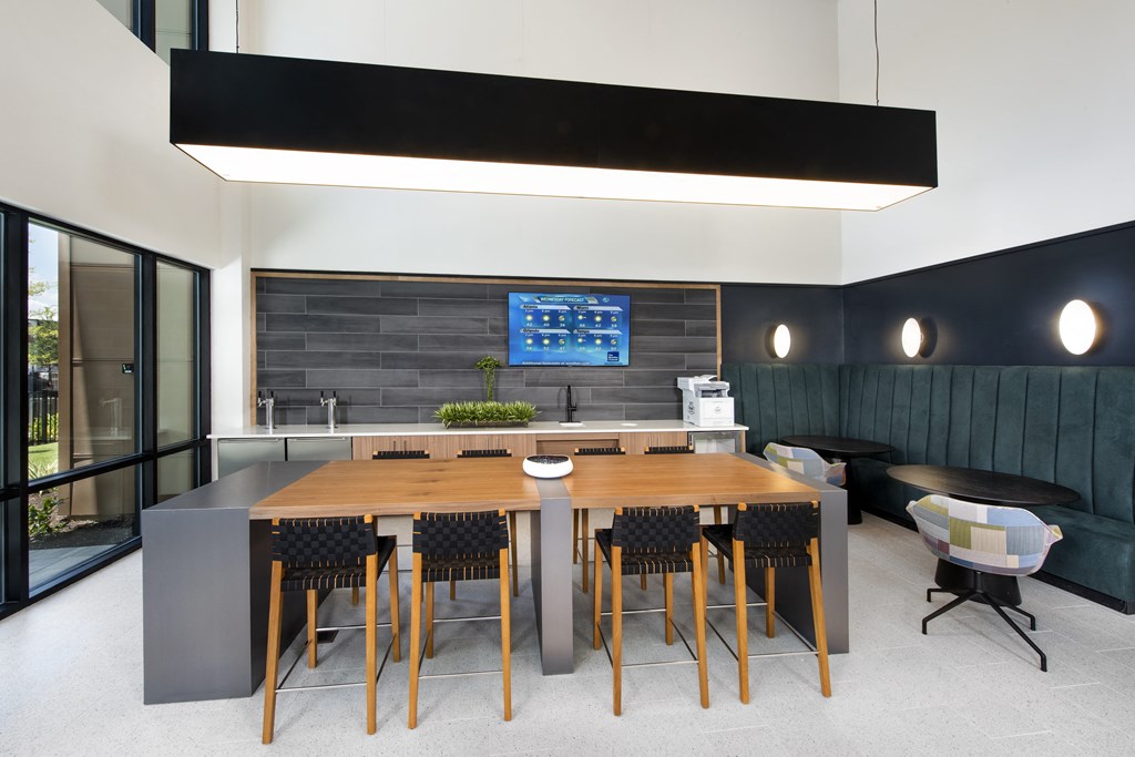 a large table and chairs in a room with a large screen tv on the wall
