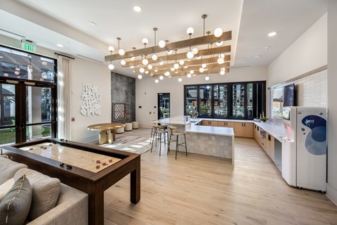 A modern kitchen with a pool table in the middle.