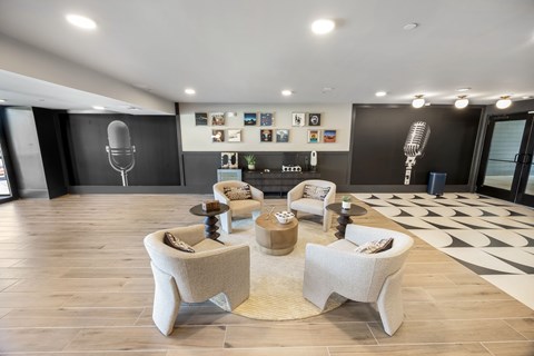 A modern living room with a black and white patterned rug and a wooden floor.