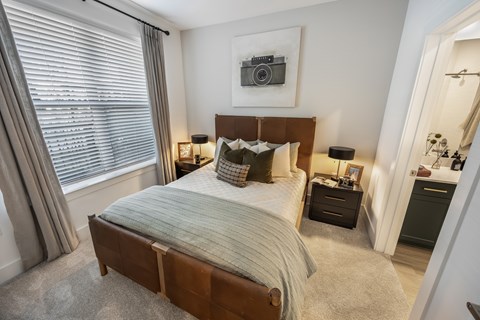 A bedroom with a large bed and a picture of a camera on the wall.