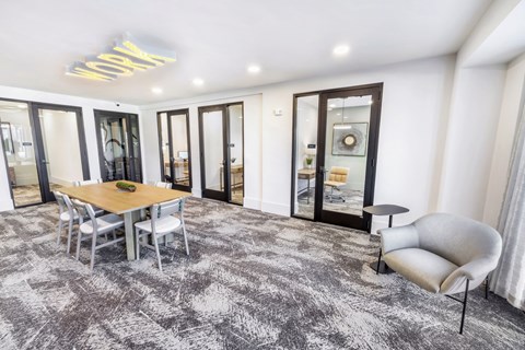 A modern dining room with a wooden table and grey chairs.