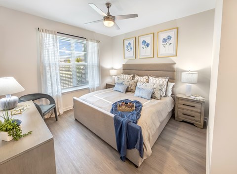 A bedroom with a bed, nightstand, and chair.