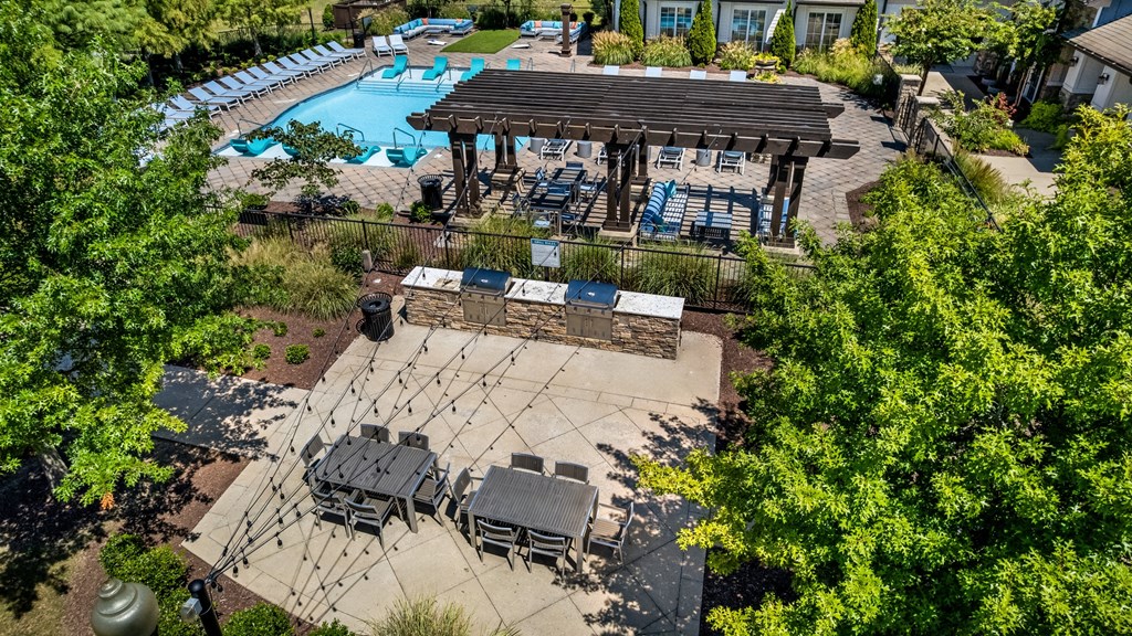 A pool area with a hot tub and lounge chairs.