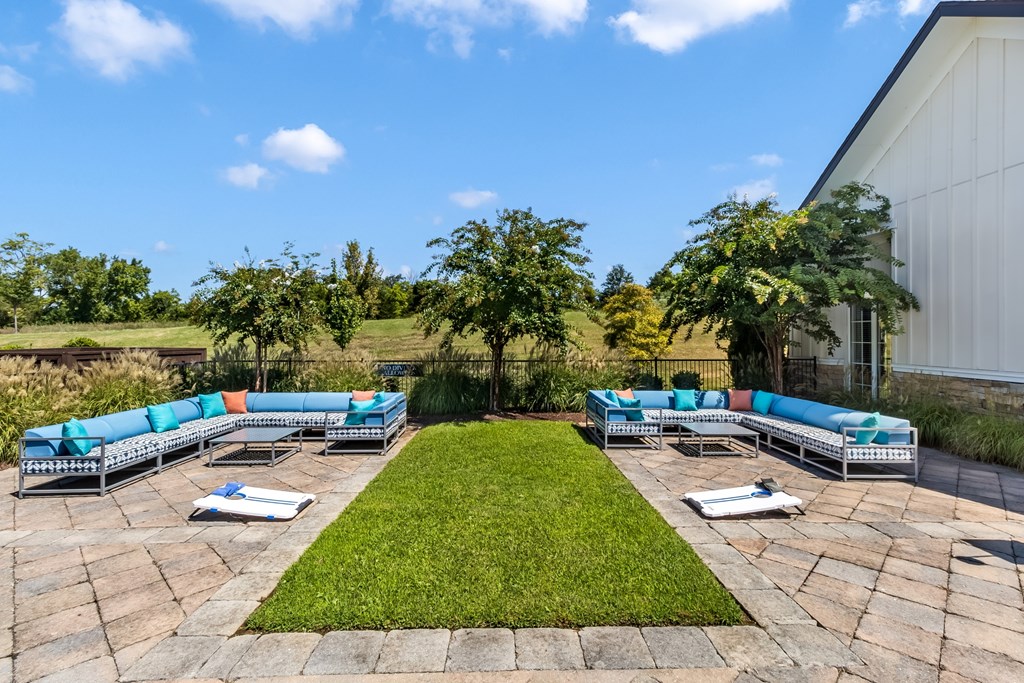 A large outdoor area with a grassy lawn and multiple lounge chairs.