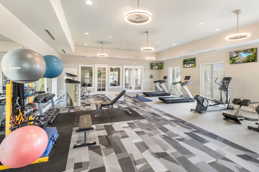 A spacious gym with a variety of exercise equipment and a treadmill.