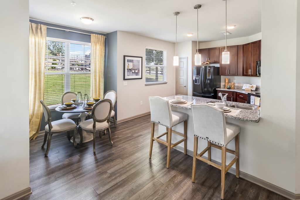 A kitchen with a dining table and chairs.