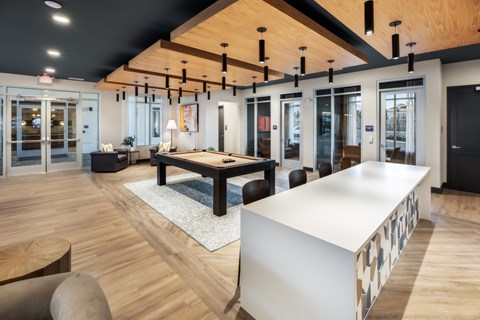 A modern office space with a long white table and wooden floors.