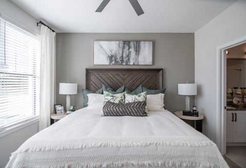a bedroom with a large bed and a ceiling fan