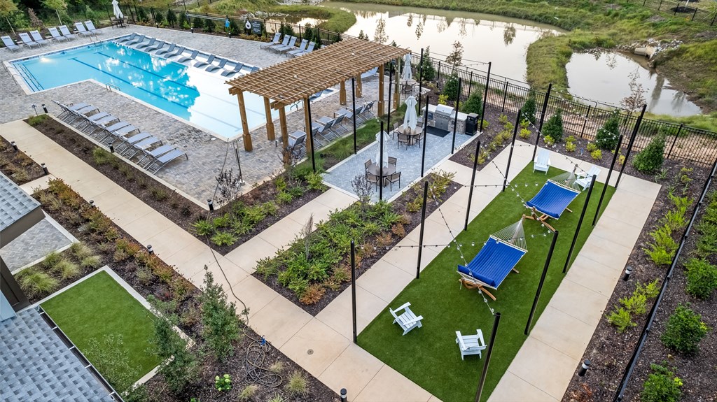 a garden with a pool and lounge chairs
