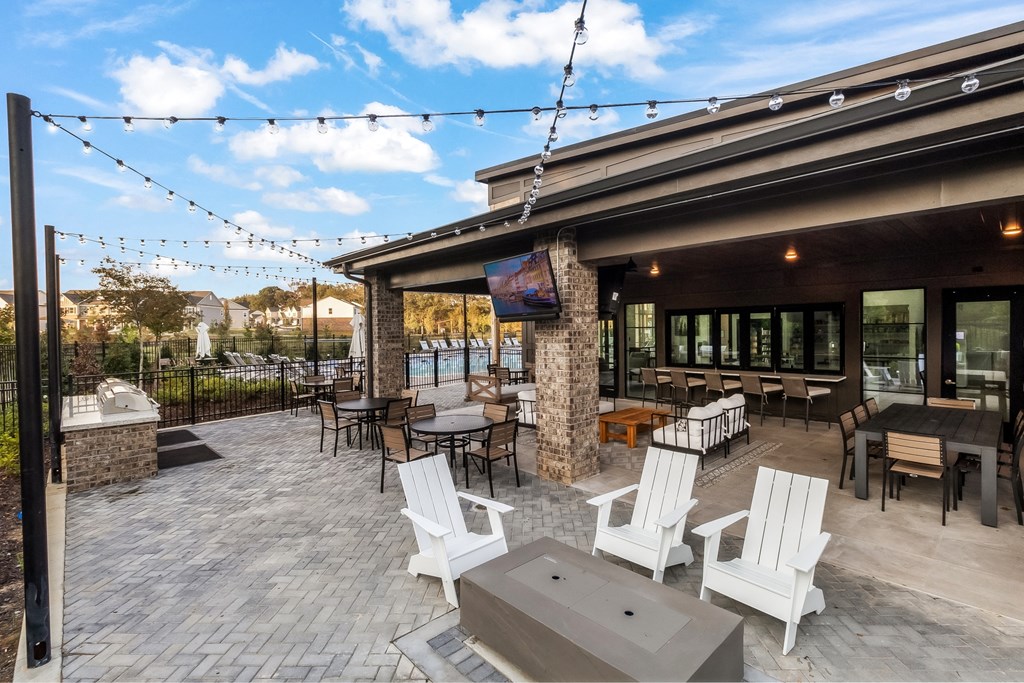 a patio with chairs and tables and a building with a pool