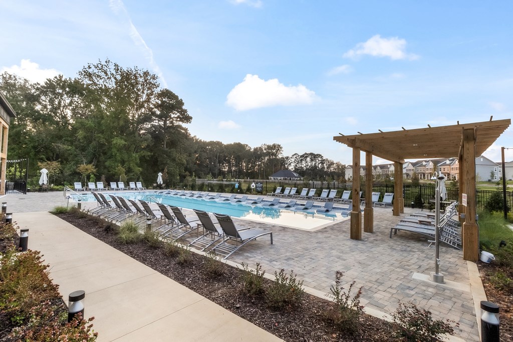 a swimming pool with chaise lounge chairs and a pool shade