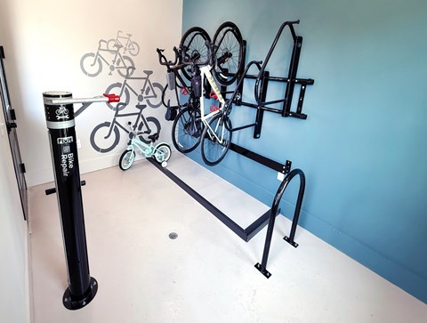 A wall-mounted bike rack with several bicycles attached.