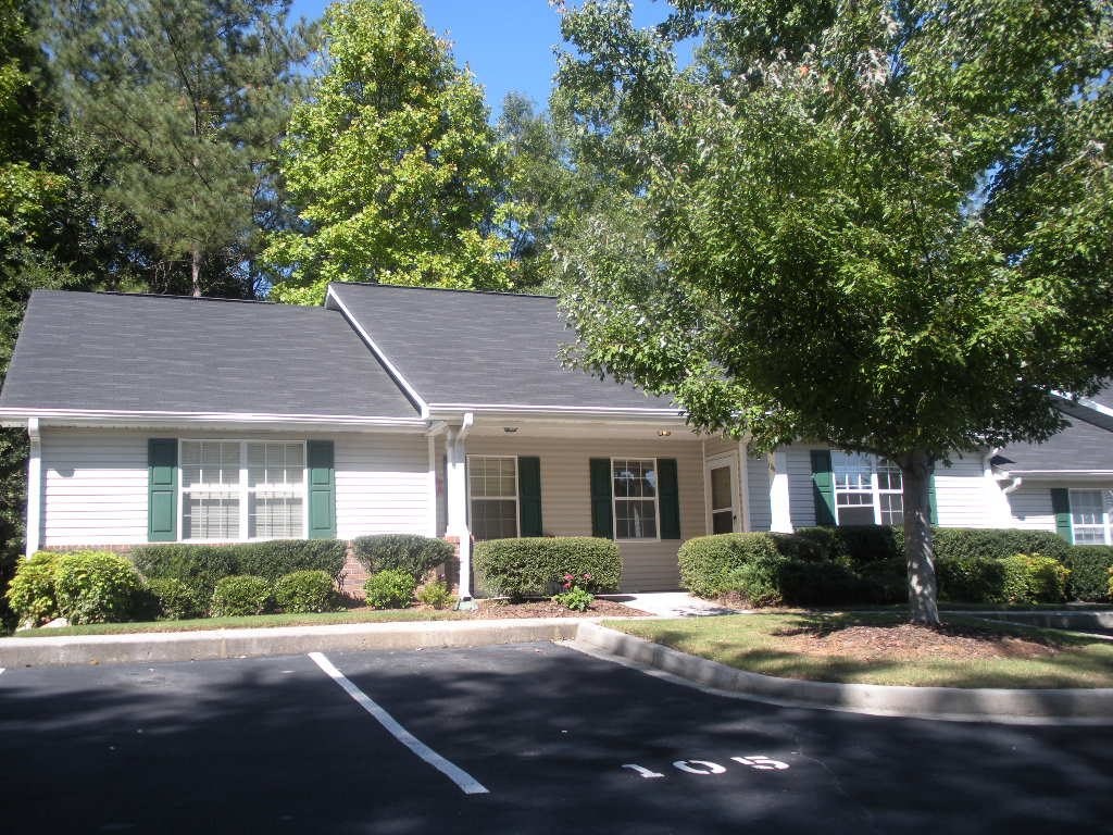 A house with green shutters and a grey roof.