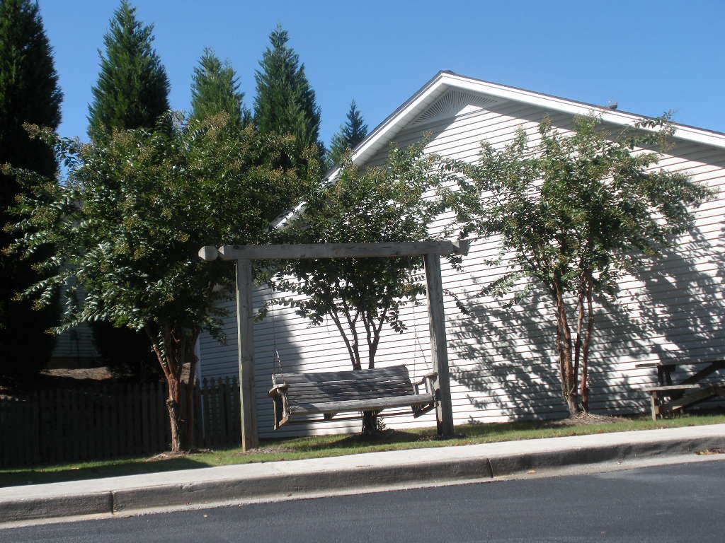 A white house with a tree in front of it.