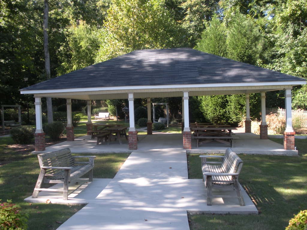 A gazebo is surrounded by benches and pillars.