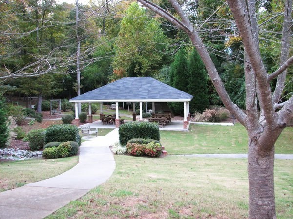 A gazebo is surrounded by trees and bushes.