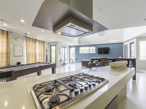 A modern kitchen with a stove top in the foreground.