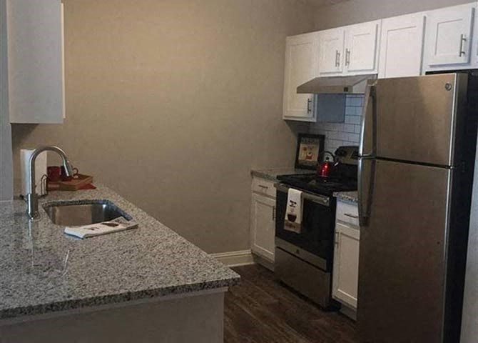 Kitchen with White Cabinetry And Black Appliances at Lullwater at Calumet, Newnan, Georgia