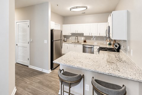 A kitchen with a white counter top and a refrigerator.