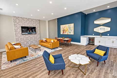 A living room with a blue accent wall and a television mounted on the wall.