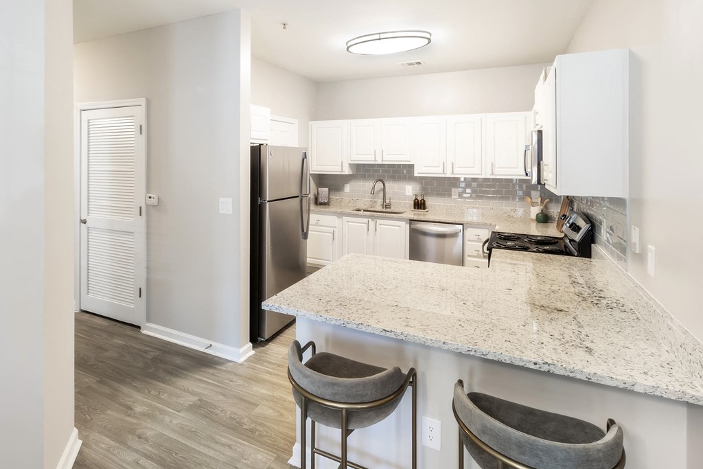 a kitchen with a marble counter top and a stainless steel refrigerator at Grayson Park Estates, Grayson, GA, 30017