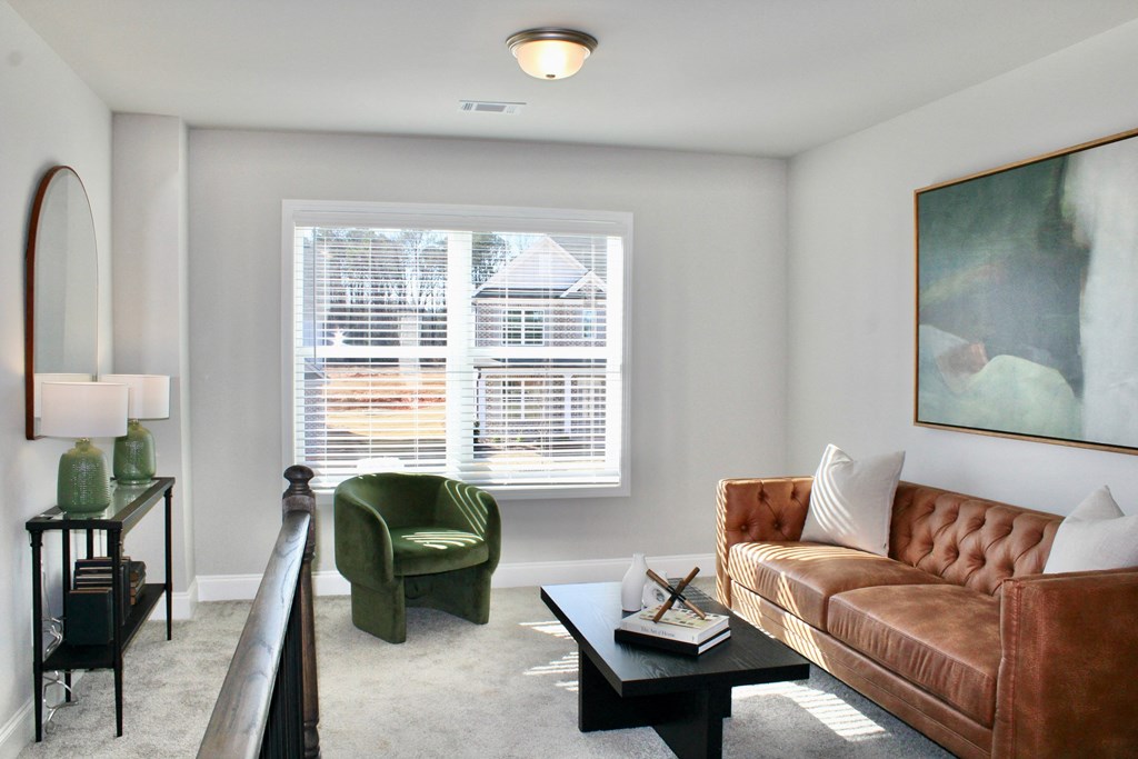 a living room with a couch and a chair and a window
