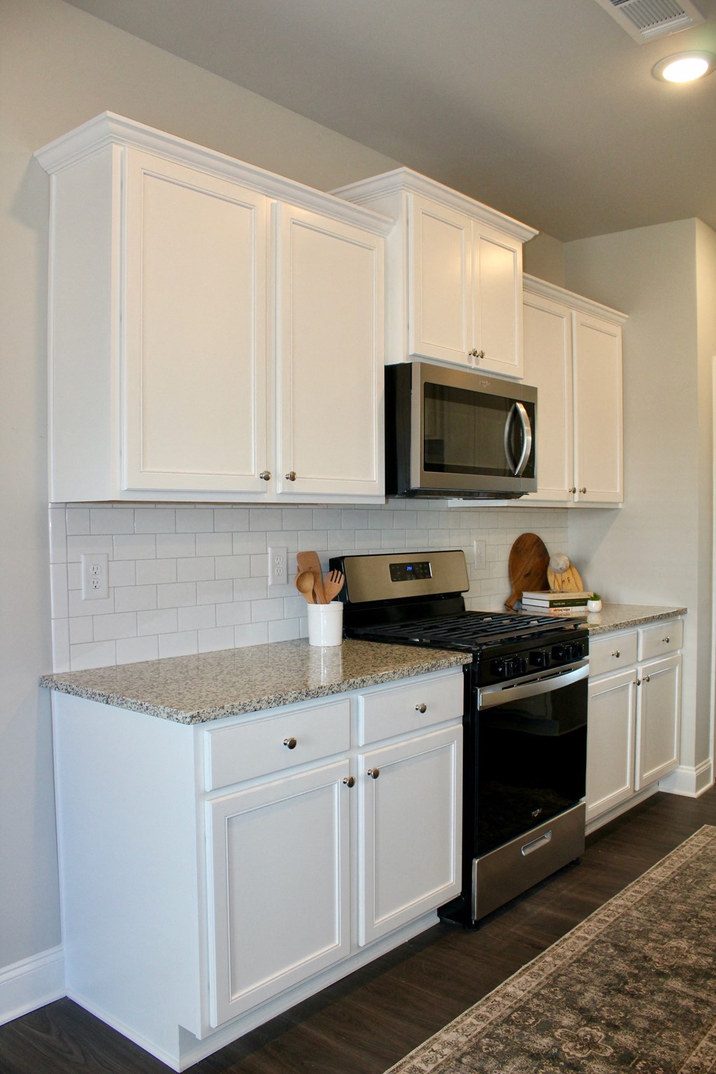 a kitchen with white cabinets and a granite counter top