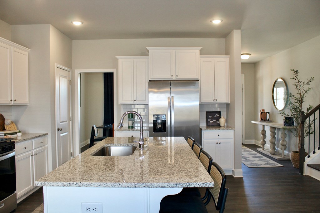 a kitchen with white cabinets and a granite counter top