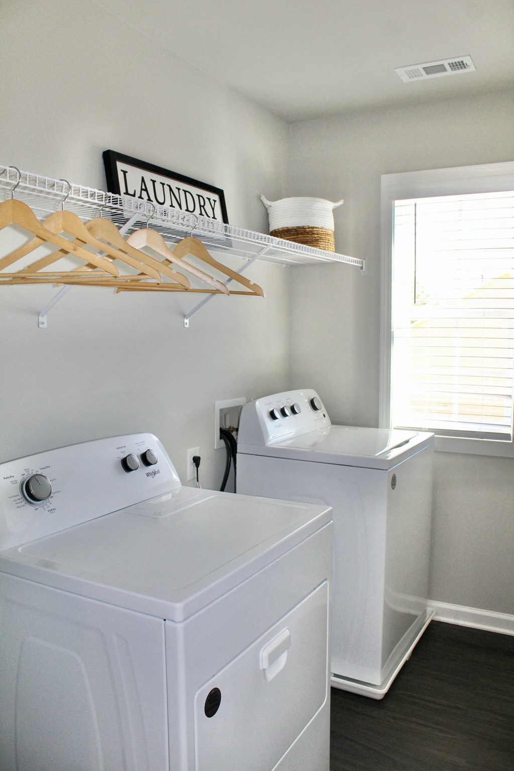 a white laundry room with two washes and a dryer