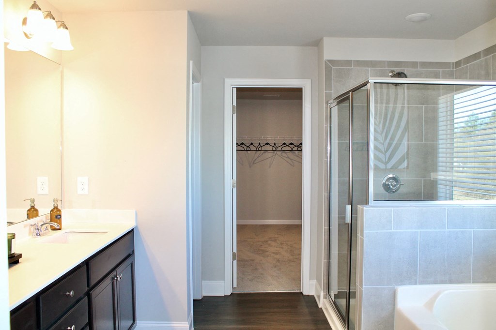 a bathroom with a shower and a sink and a mirror