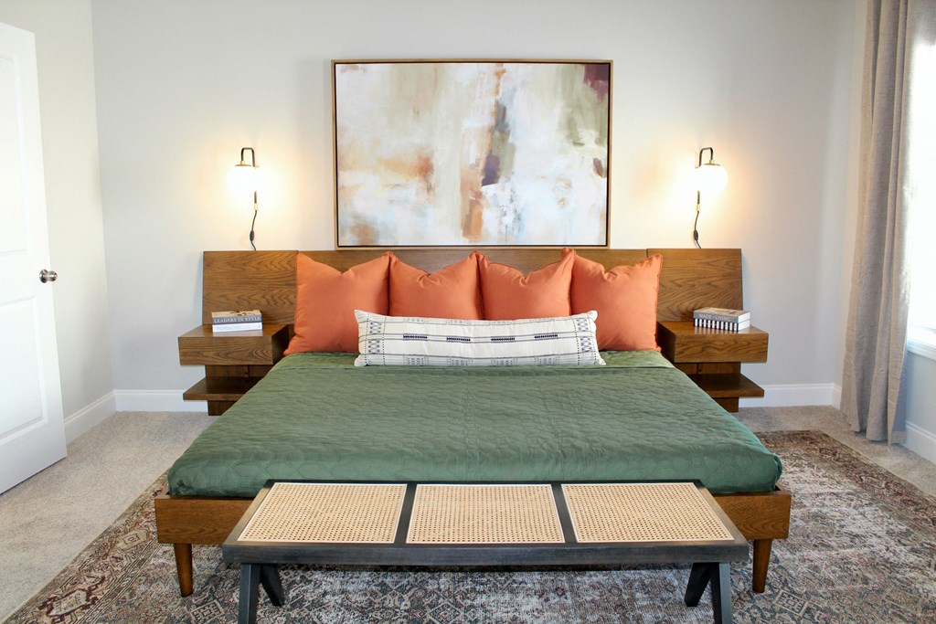 A bed with a green cover and orange pillows is in the image. at The Dawson Cartersville in Cartersville, GA 30191