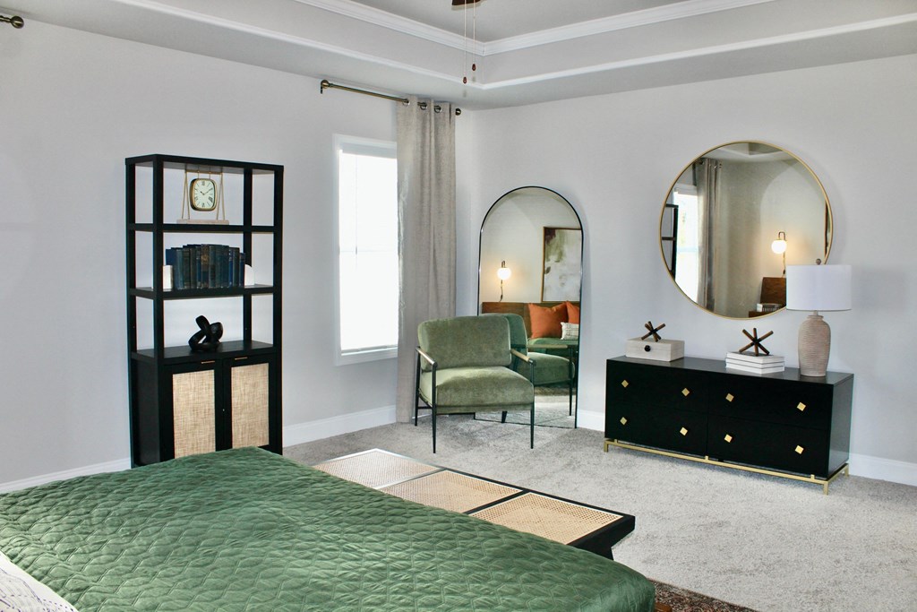 a bedroom with a green bed and a black dresser and a mirror