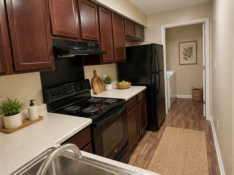 A kitchen with black appliances and wooden cabinets.