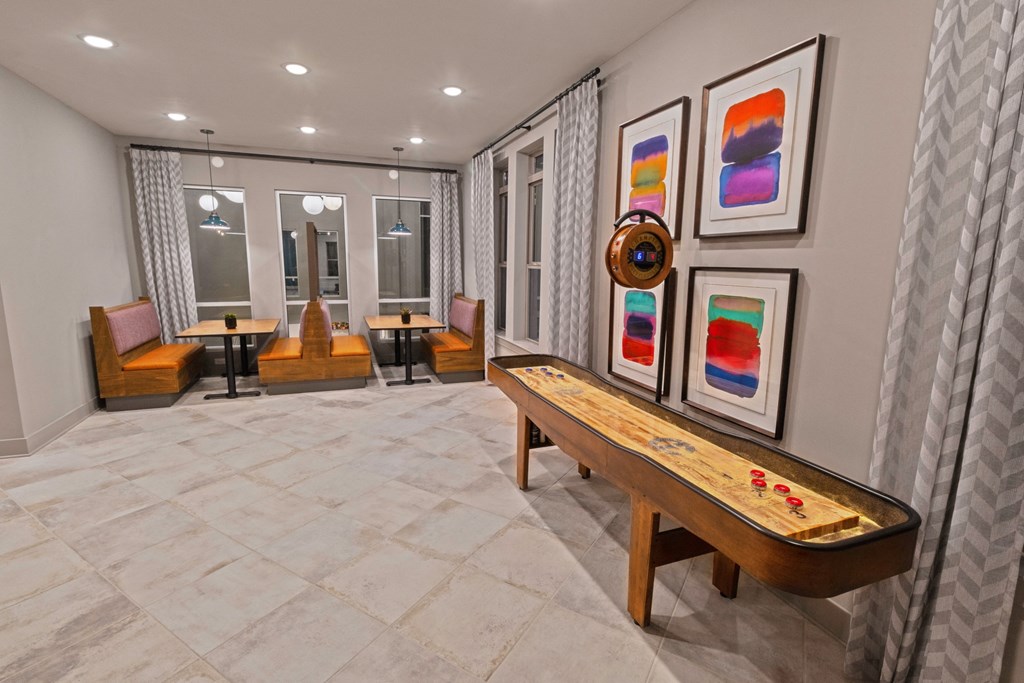 a living room with a wooden bench and paintings on the wall