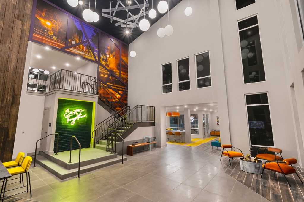 the lobby of a building with stairs and a green door