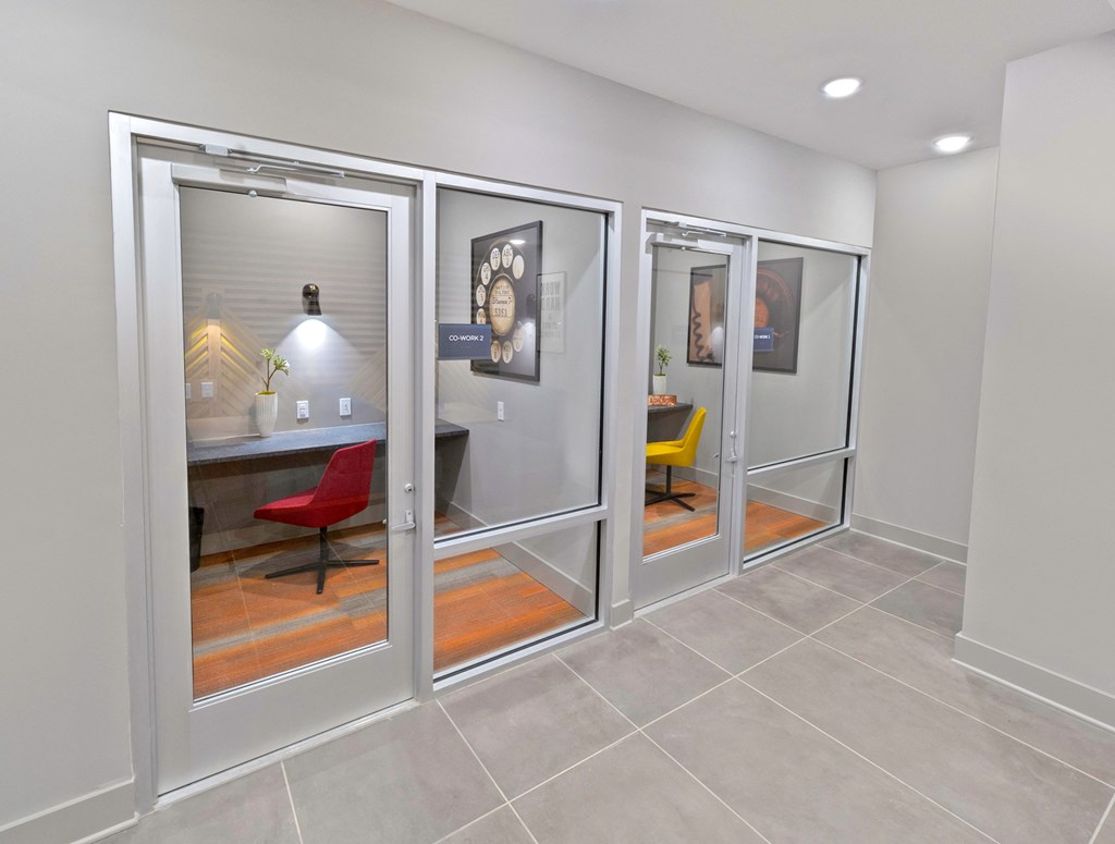 an office with sliding glass doors and a table with chairs