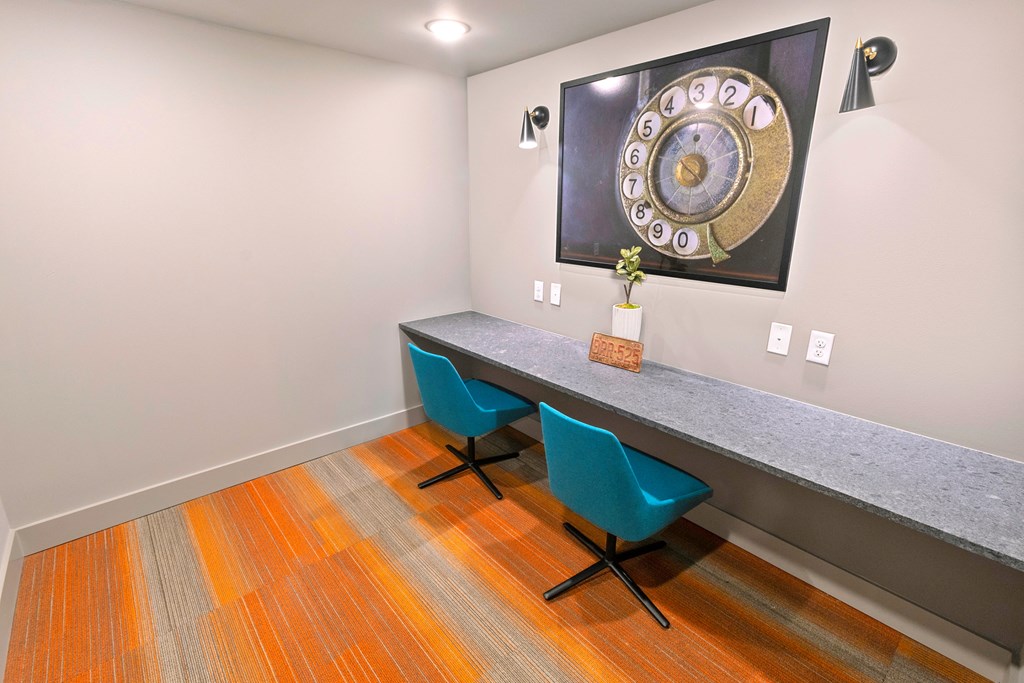 a home office with a desk and two blue chairs