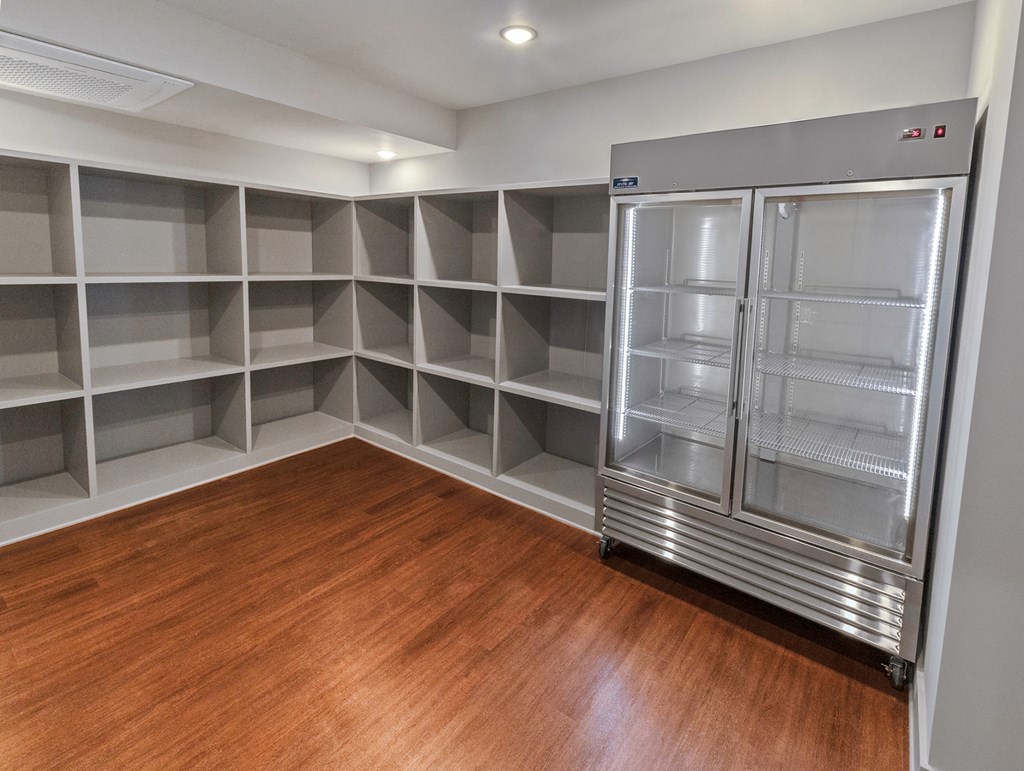 a walk in closet with shelves and a refrigerator