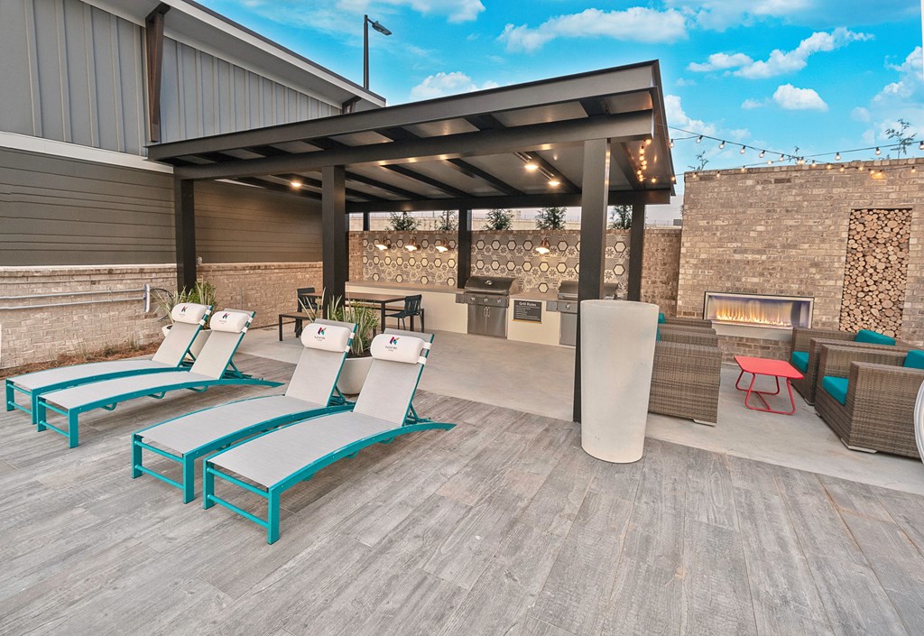 a patio with lounge chairs and a fire pit